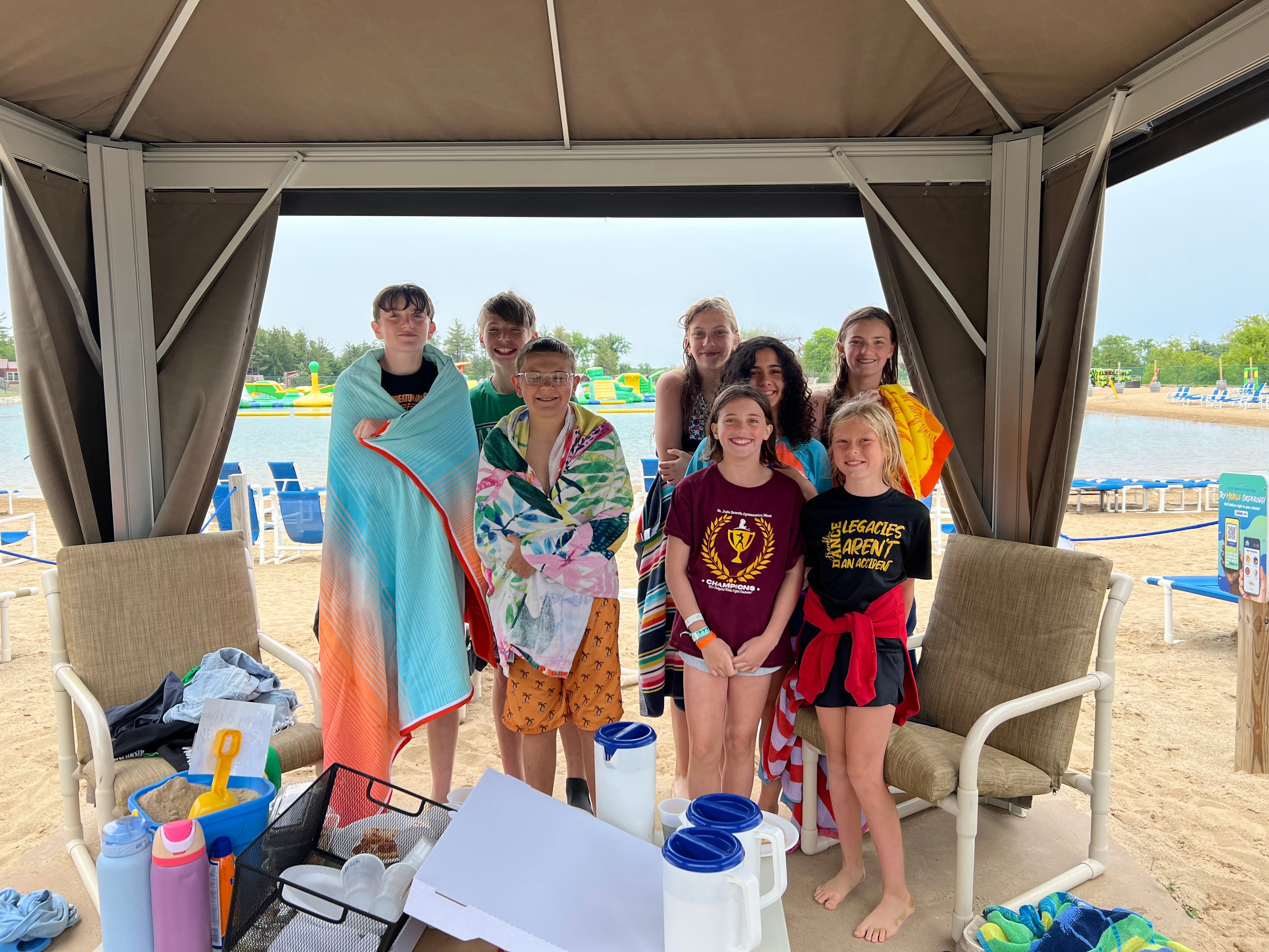 Kids enjoying time in the shade under a cabana after lots of fun in the water at Bear Paw Adventure Park.
